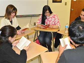 Students at desks reading from books