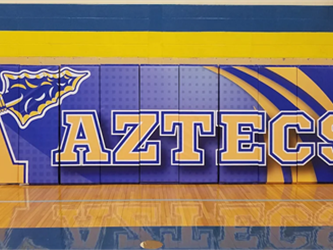 The wall in the gym with Aztecs branding