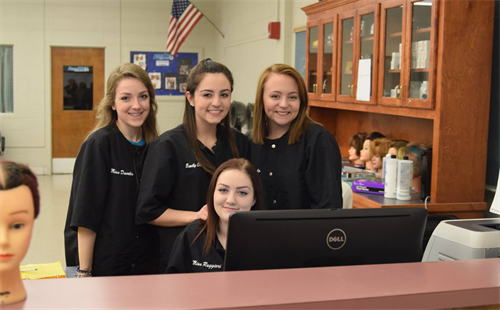 Cosmetology students behind a check in desk