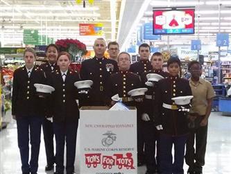 MJROTC students in uniform with toys for tots box